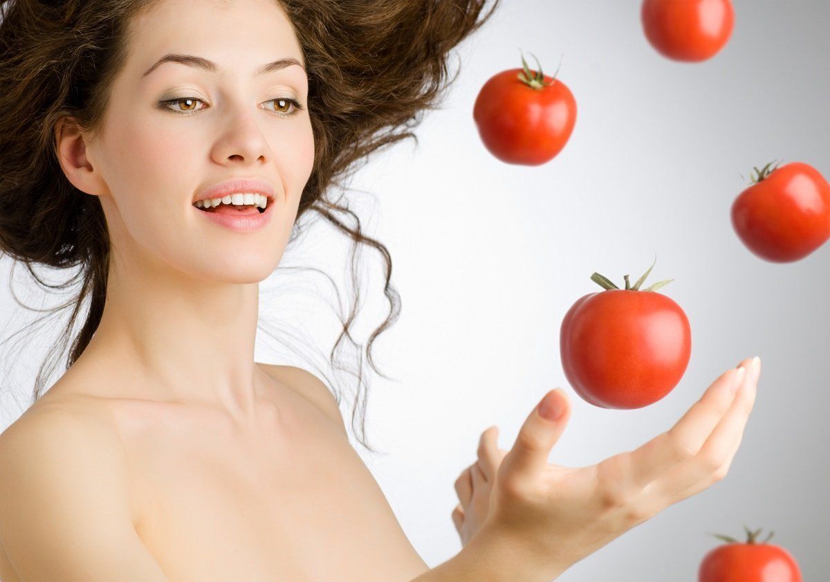 a girl with a ripe red tomato