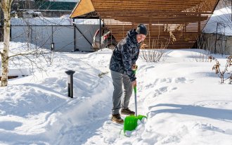 shutterstock.com/nieriss: Мужчина чистит снег во дворе