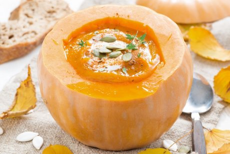 spicy vegetable cream soup in a pumpkin, close-up, horizontal