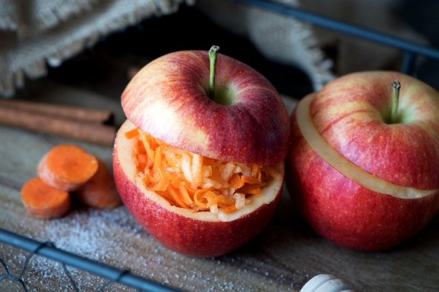 A healthy salad of carrots and apples sprinkled with sugar in an apple. Healthy dessert